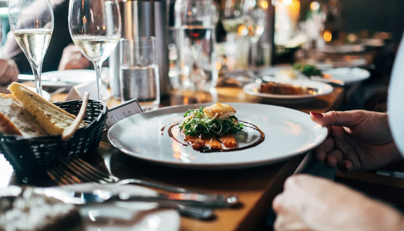A set table with plates, glasses, and bread